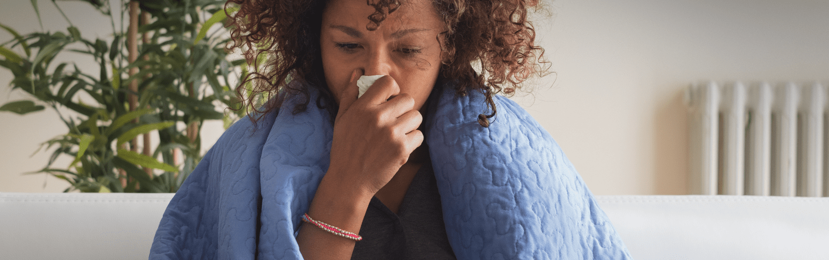 Woman sick with COVID19 reviewing a thermometer